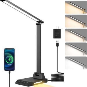 Black ShineTech LED desk lamp with a slim adjustable arm and rectangular light panel, shown illuminating in multiple color temperatures from warm yellow to cool white. The lamp base features touch controls and a USB‑C charging port connected to a smartphone displaying a charging icon, alongside a black power adapter and coiled cable.