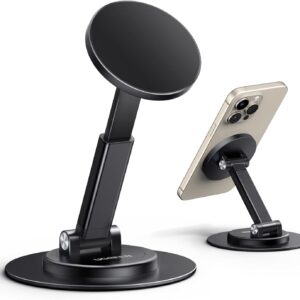 Two black UGREEN magnetic phone stands with circular bases and adjustable arms, each featuring a round magnetic pad for holding smartphones. One stand is empty, while the other supports a gold iPhone with triple cameras, demonstrating the MagSafe attachment and flexible viewing angles.