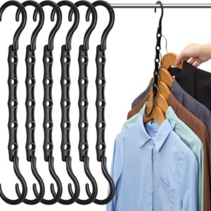 Six black cascading space‑saving hangers hanging on a closet rod, each with multiple slots for vertical clothing organization. One hanger holds several wooden hangers with collared shirts in assorted colors—light blue, mint green, brown, gray, and black—demonstrating efficient closet storage