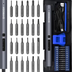 A neatly arranged SHARDEN mini electric screwdriver kit displayed in a black storage case. The set includes a slim metallic gray electric screwdriver, a USB charging cable, a blue magnetic holder, and 24 precision bits engraved with labels such as PH000, T5H, and Y1.5. Each bit is organized in rows for easy identification, showcasing a professional and compact design ideal for repairing phones, cameras, laptops, and watches.