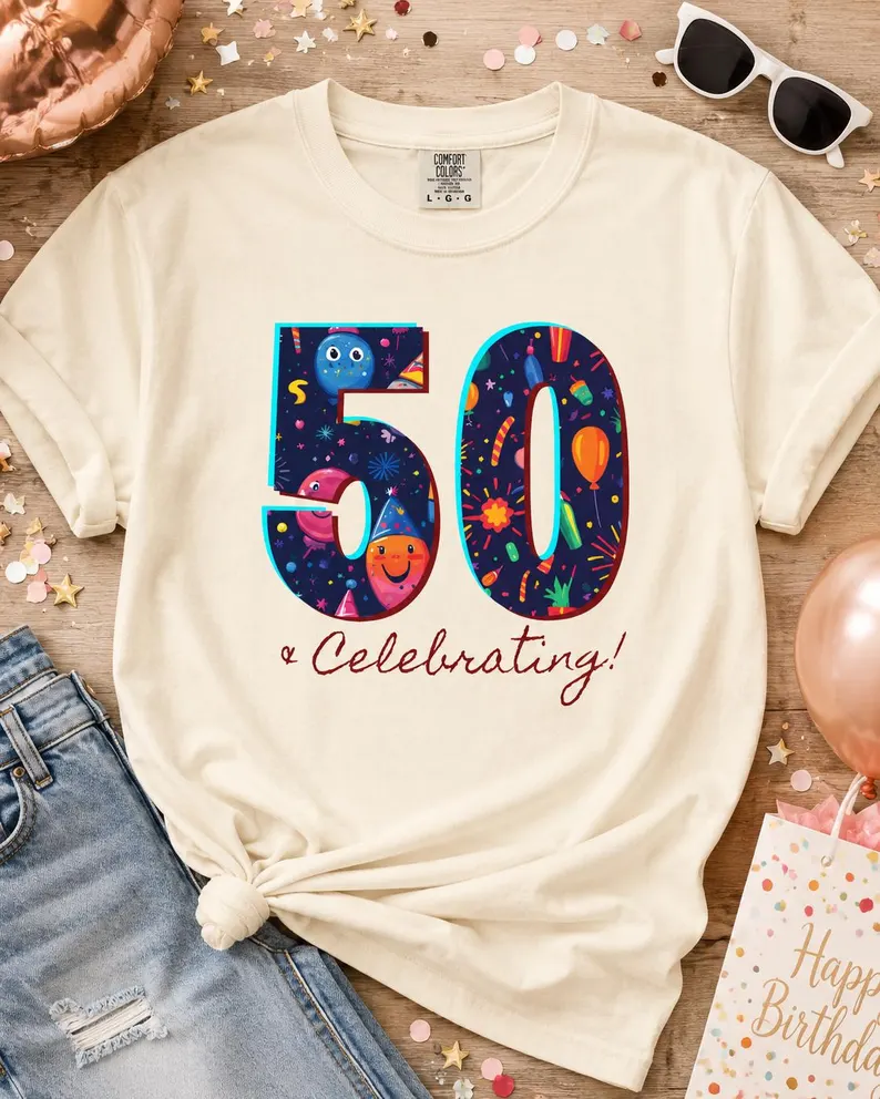 A cream celebrating 50 shirt featuring colorful party illustrations inside the number “50” with fireworks, balloons, and confetti, styled with jeans, sunglasses, and birthday decorations.
